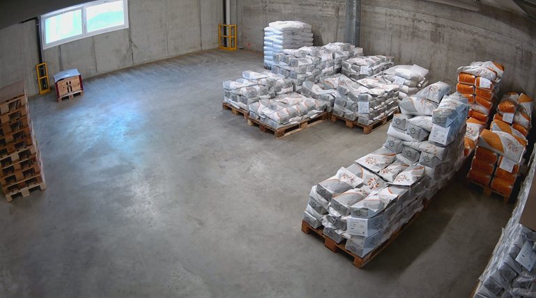 Live-Bild der Kamera aus dem Lager: Betonhalle mit Paletten voller Warensäcke, guter Überblick über den ganzen Raum