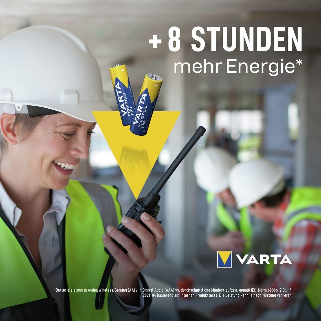 Bauarbeiterin mit Funkgeraet und der Herstellerangabe plus acht Stunden mehr Energie mit Fußnote